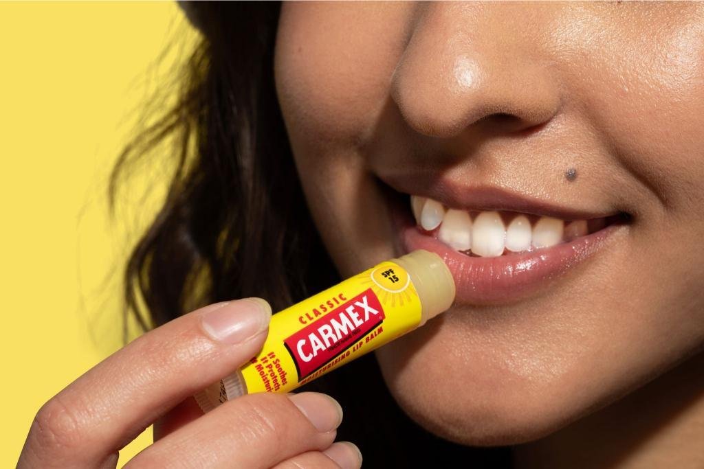 Applying Carmex Classic lip balm