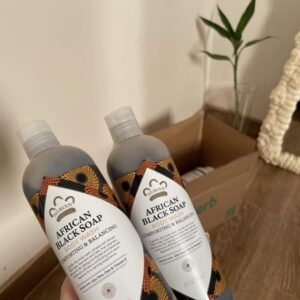 Two Nubian Heritage African Black Soap body wash bottles with an iHerb order in the background