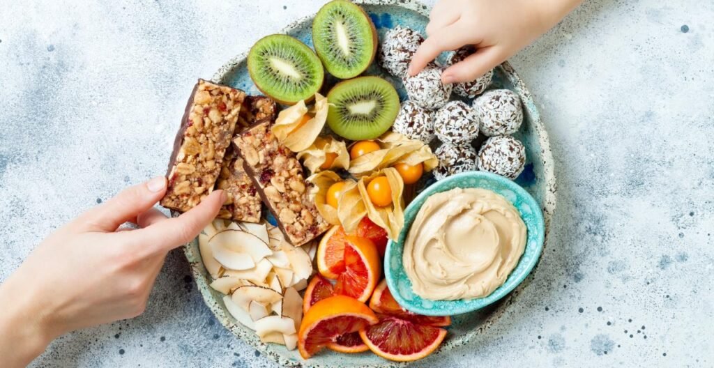 Healthy snack platter with granola bars, fruit, and nut butter